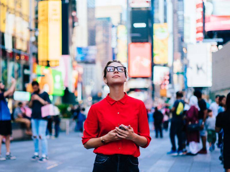 Žena usred grada s mobitelom